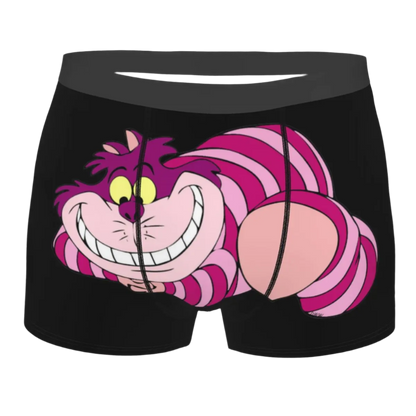 boxer shorts featuring the Cheshire Cat design from Alice in Wonderland, with glowing turquoise eyes and distinctive grinning teeth illuminated against a dark background.