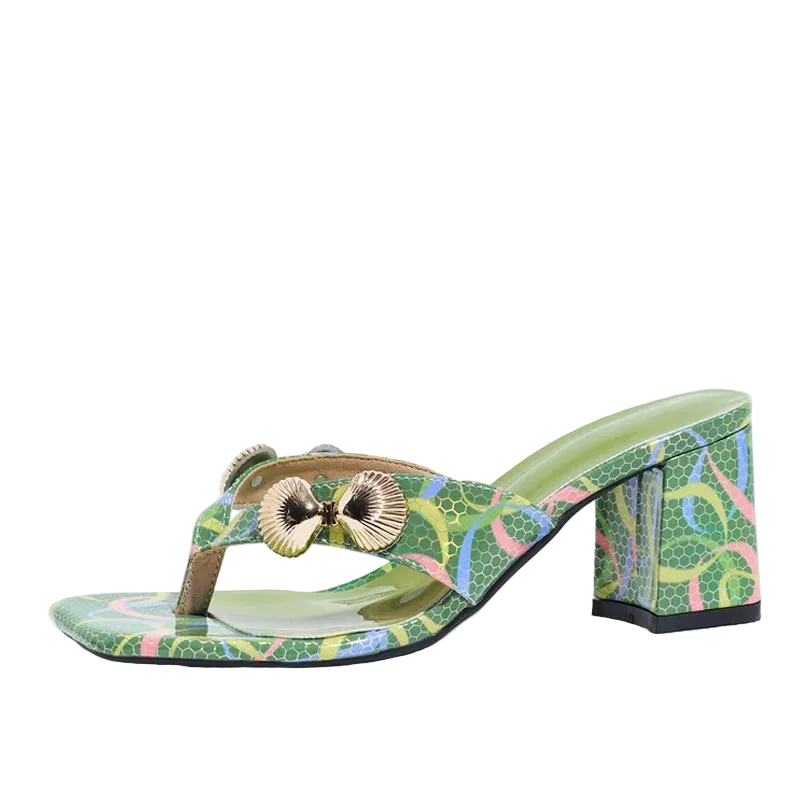 A green patterned thong sandal with a block heel, featuring a metallic gold shell-shaped ornament on the strap, shown against a plain white background.