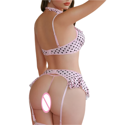 Person wearing a polka dot lingerie set in a bedroom setting with pink decor.