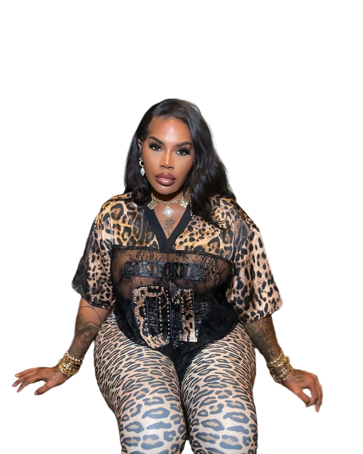 Woman sitting on a bench wearing a leopard print outfit with a black top.