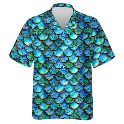 A short-sleeve button-up camp shirt featuring an all-over mermaid scale pattern in shades of blue, teal, and green, displayed on a clean white background.