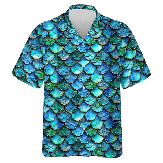 A short-sleeve button-up camp shirt featuring an all-over mermaid scale pattern in shades of blue, teal, and green, displayed on a clean white background.