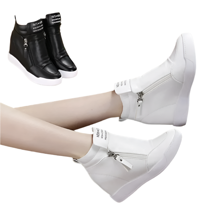 White wedge sneakers with zippers worn by a person sitting on a brown leather chair.