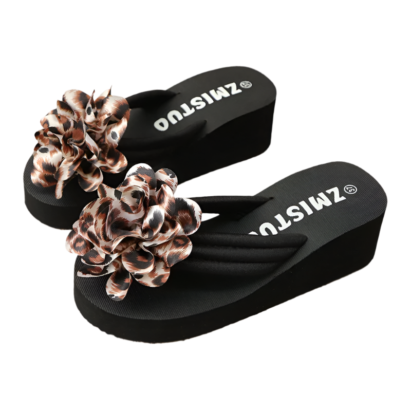 Black flip-flops with leopard print flowers on a textured surface