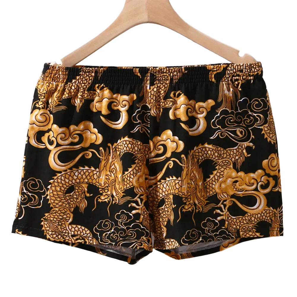 Black shorts with gold dragon and cloud patterns on a hanger