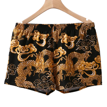 Black shorts with gold dragon and cloud patterns on a hanger