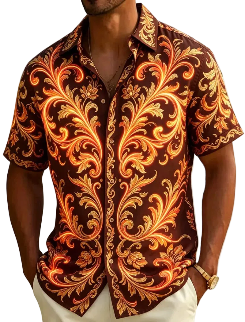 A man wearing a short-sleeve button-up shirt with an ornate baroque-style scroll pattern in orange, yellow, and white over a dark brown base, photographed outdoors near palm leaves and a beach.