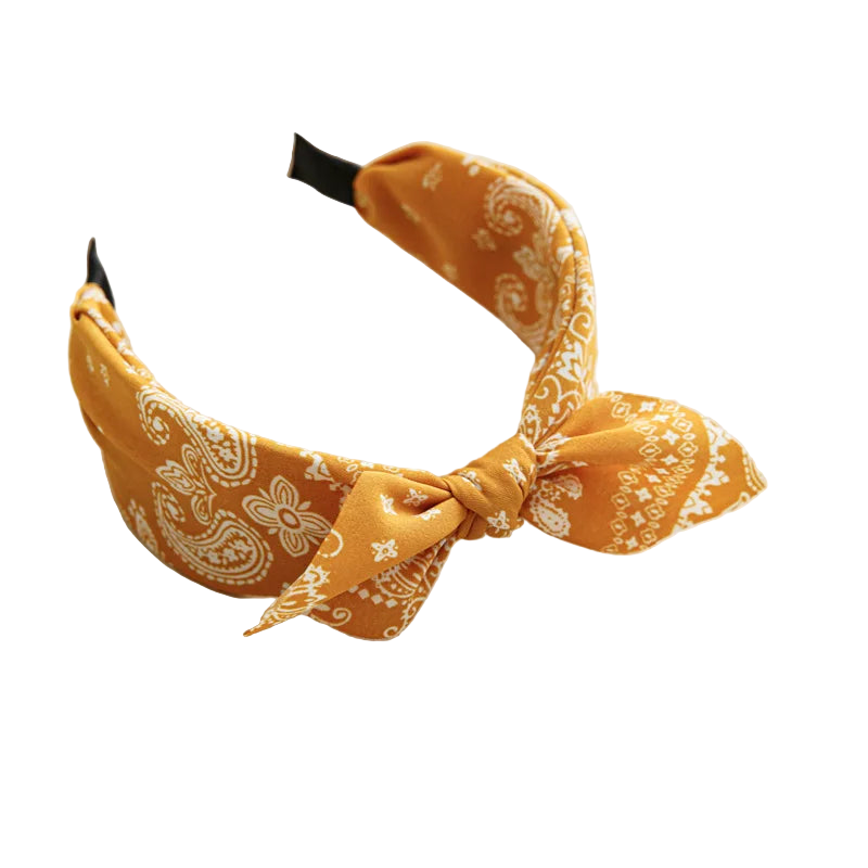 Yellow patterned headband on a white tray with a cup and coaster in the background