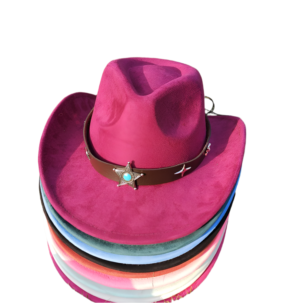 Stack of colorful cowboy hats with a purple top hat featuring a star and turquoise stone on grass.