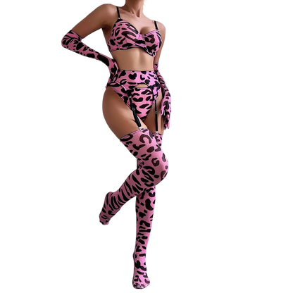 Person wearing a pink leopard print outfit with long gloves and stockings against a white wall.