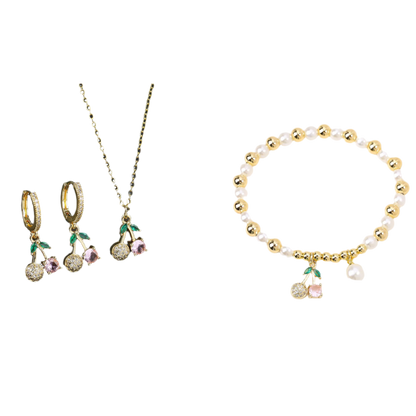 Jewelry set with cherry-themed earrings, necklace, and bracelet on a black and white background.