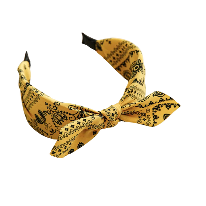 Yellow headband with black patterns on a beige tray