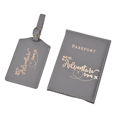 A passport holder and luggage tag set with the phrase "And so the adventure begins" in elegant script. The design is sleek and stylish, perfect for travel.