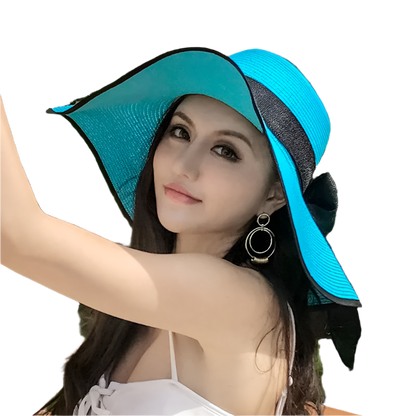 Woman wearing a blue and black sun hat outdoors with greenery in the background