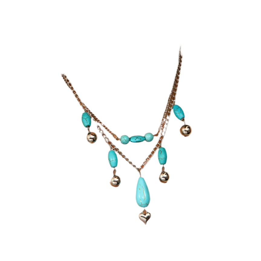 Necklace with turquoise beads and silver heart pendant on a white top