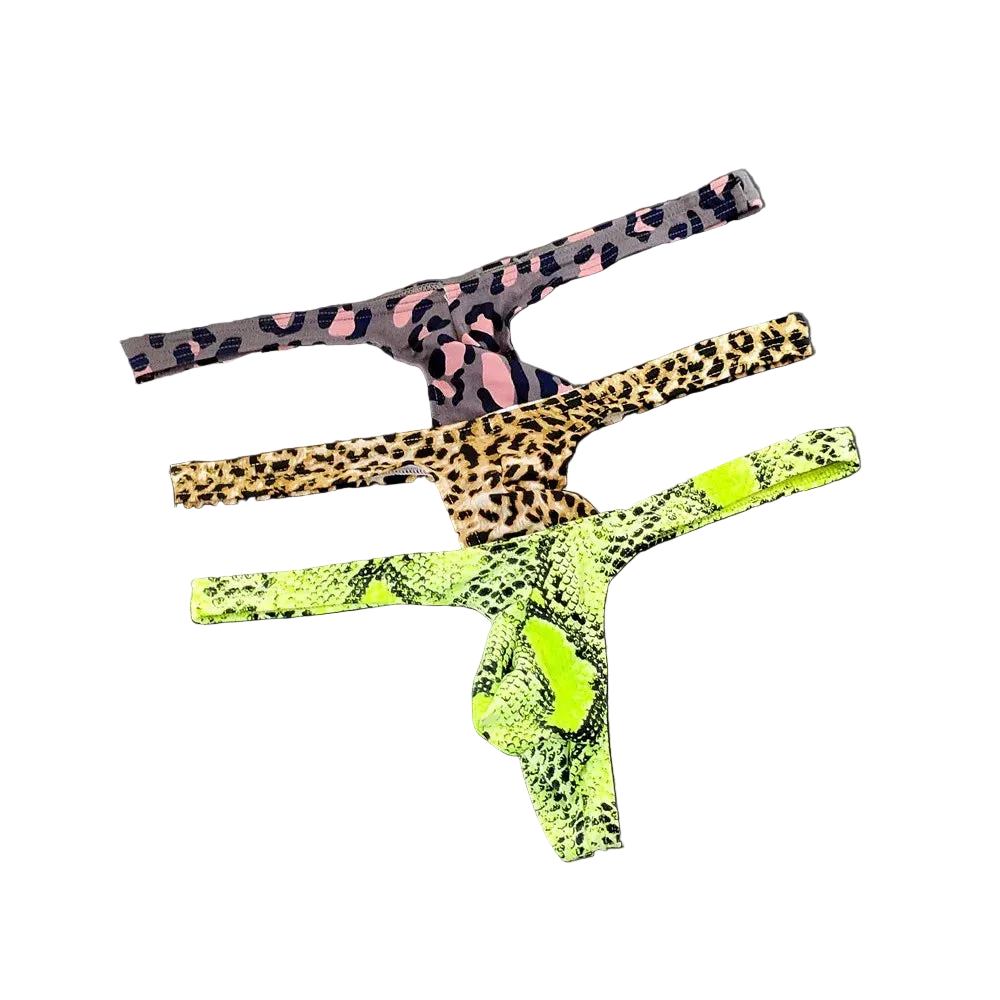 Three pairs of leopard-print thong underwear stacked diagonally on a dark gray background. The top pair is black and pink leopard print, the middle is tan and brown leopard print, and the bottom is a bright neon green and black snakeskin print.