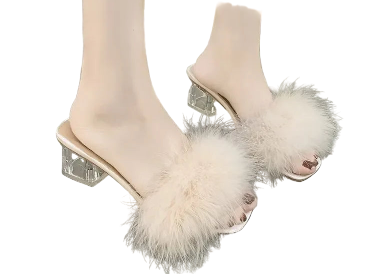 Beige open-toe high-heeled shoes with fluffy details on a gray floor.