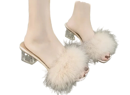 Beige open-toe high-heeled shoes with fluffy details on a gray floor.