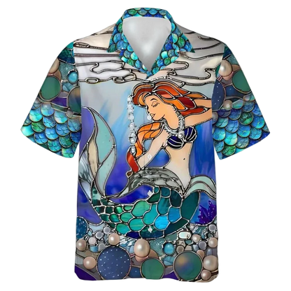 A short-sleeve button-up camp collar shirt featuring a colorful stained-glass style illustration of a mermaid with orange hair and a teal tail, set against an underwater scene with pearls and blue water.