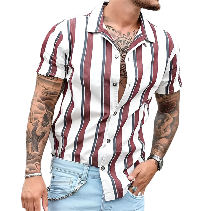 Man wearing a striped shirt with tattoos on arms, standing outdoors.
