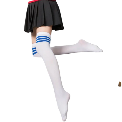 Person wearing white knee-high socks with blue stripes sitting on a gray couch.