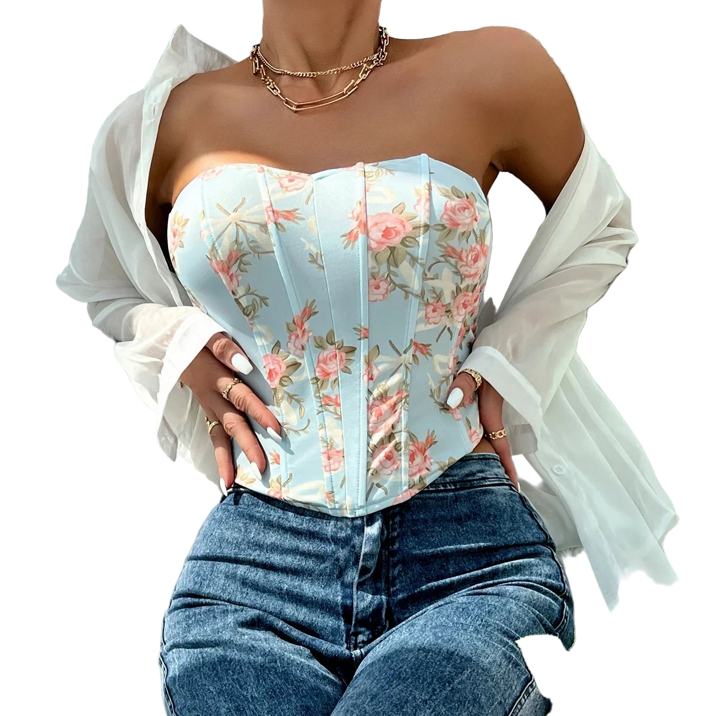 Person wearing a floral corset top and jeans on a fluffy white surface.