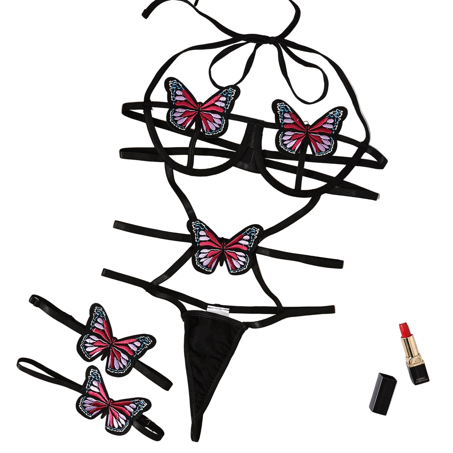Black lingerie set with butterfly designs on a beige surface with flowers and a magazine.