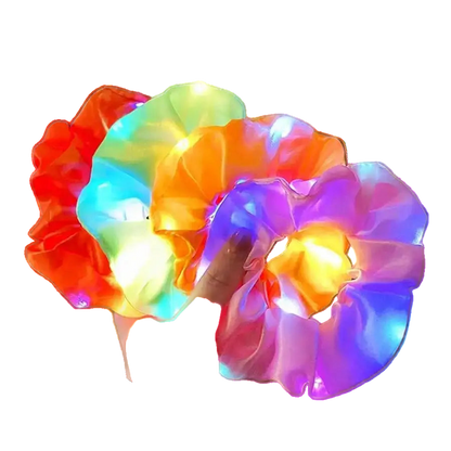 Colorful LED scrunchies being held in a hand with a blurred outdoor background