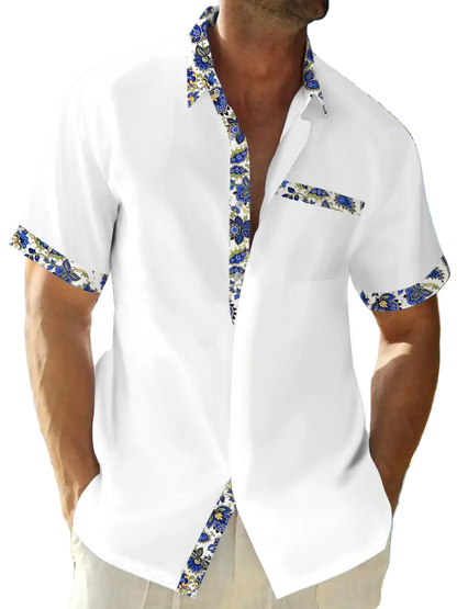 Man wearing a white shirt with floral trim on a beach