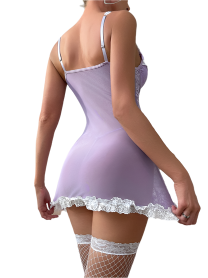 Woman wearing a lavender nightgown with lace trim in a bedroom setting.