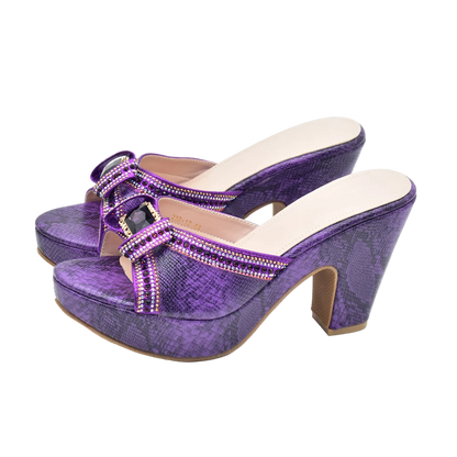 Purple high-heeled shoes with embellishments on a white background