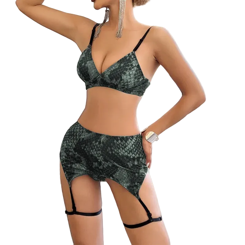 Woman wearing a green snakeskin-patterned lingerie set in a room with large windows.