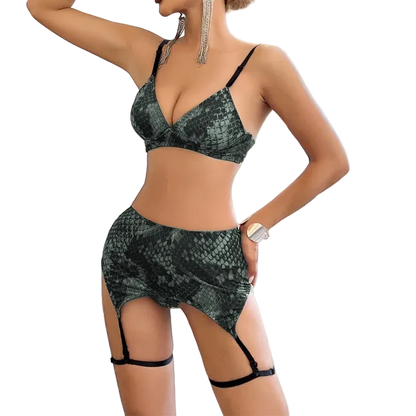 Woman wearing a green snakeskin-patterned lingerie set in a room with large windows.