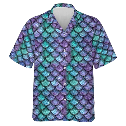 A short-sleeve button-up camp shirt featuring an all-over mermaid scale pattern in shades of purple, teal, and blue, displayed on a clean white background.