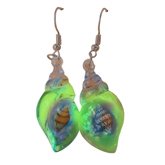 Glowing green shell-shaped earrings with embedded shells on a beige background