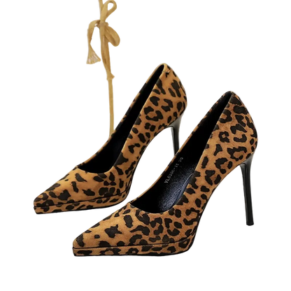 Leopard print high-heeled shoes on a white surface with a blurred background