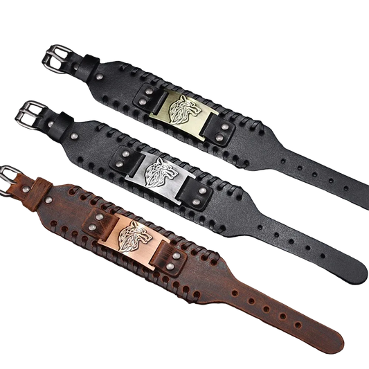 Three leather wristbands with metal buckles on a textured surface.
