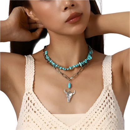 Woman wearing a turquoise beaded necklace with a silver bull head pendant.