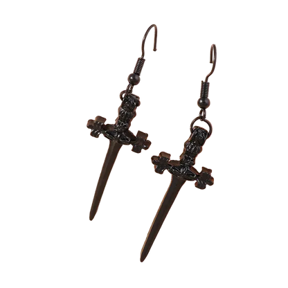 Black dagger-shaped earrings on a beige background