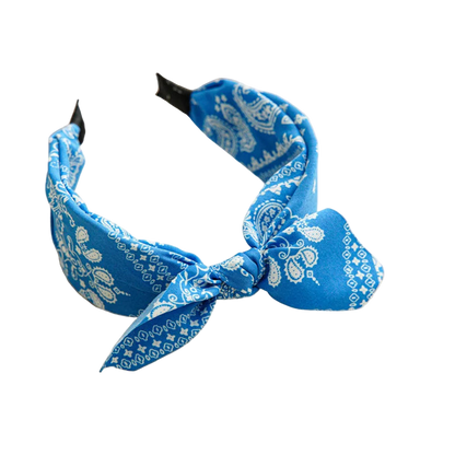 Blue bandana headband with white patterns on a beige tray.