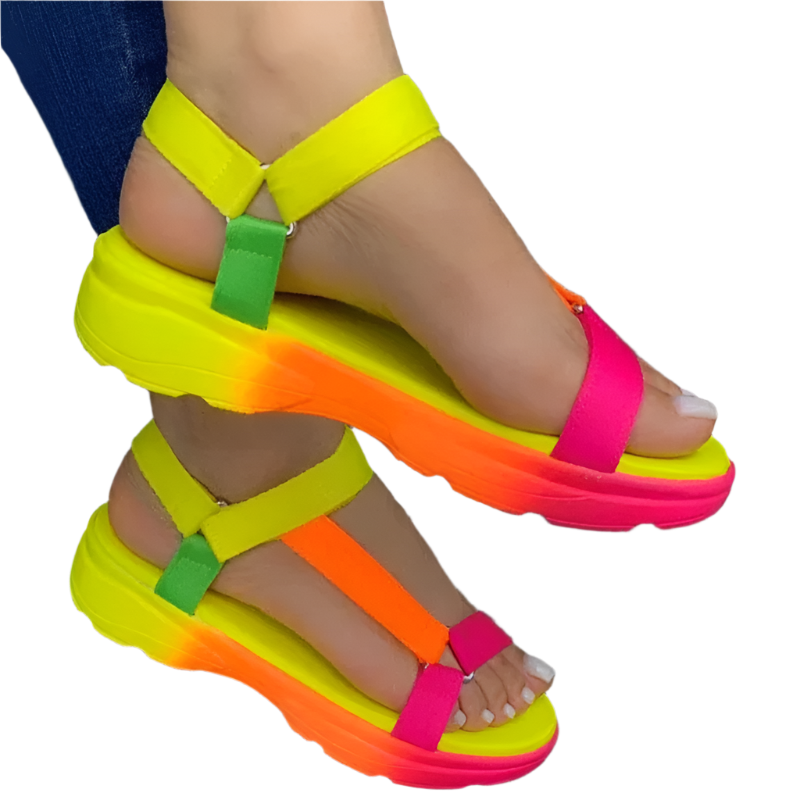 Neon colorful sandals on a person's feet with a dark background