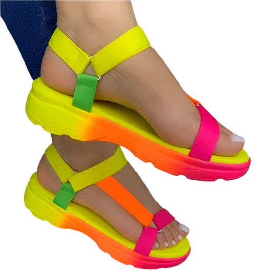 Neon colorful sandals on a person's feet with a dark background