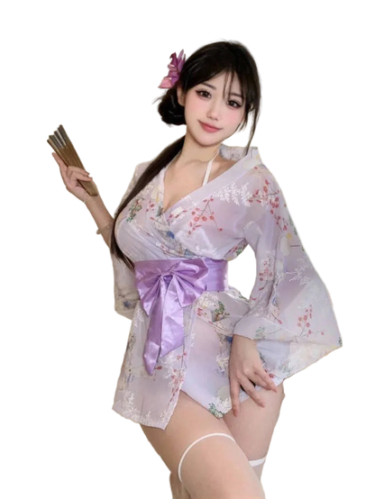 Woman in a floral kimono with a purple ribbon sitting on a couch.