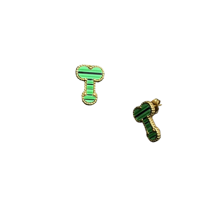 A pair of green and black striped enamel earrings with gold-tone borders, displayed on a textured black surface next to a black foam block.