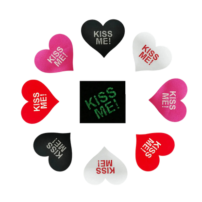Heart-shaped stickers with 'KISS ME!' text in various colors on a white background