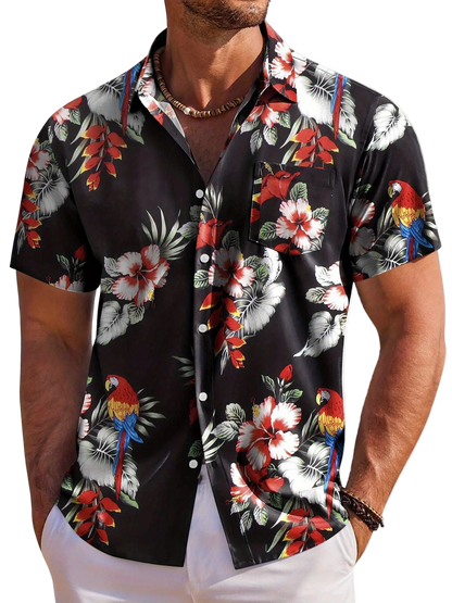 Man wearing a black floral and parrot patterned shirt on a white background