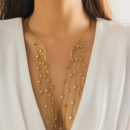 Gold star-shaped necklace on a model wearing a white outfit