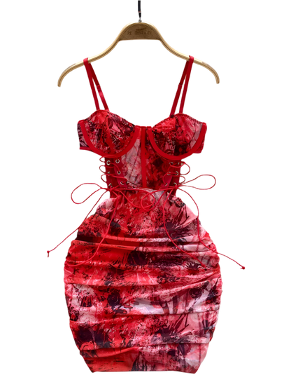 Red floral dress on a hanger with a white fur rug and flowers in the background