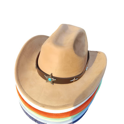 Brown cowboy hat with a star and turquoise stone on a stack of colorful hats on grass