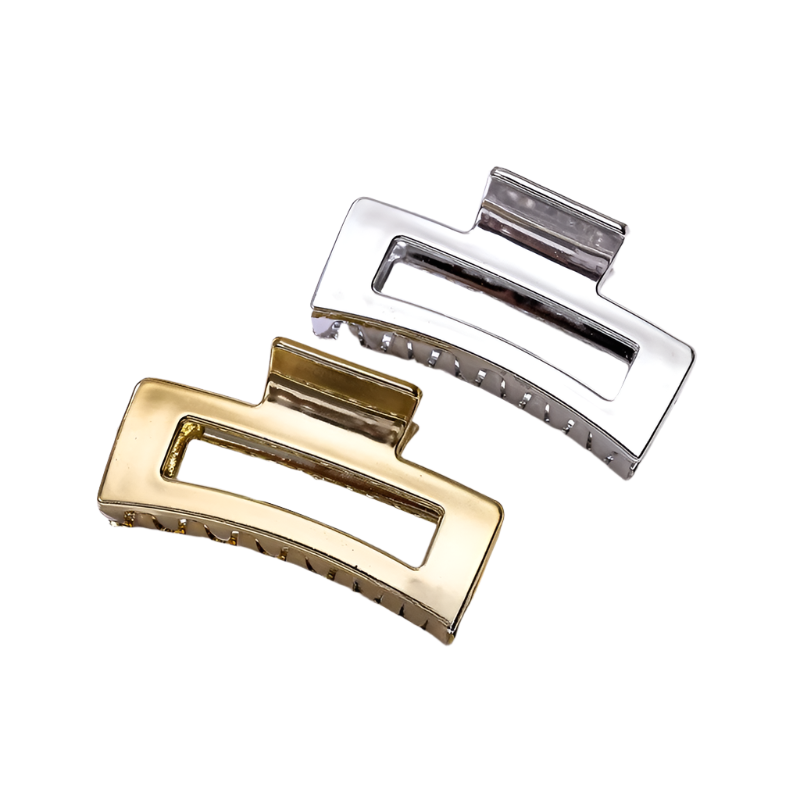 Gold and silver hair clips on a white surface with 'PARIS' text in the background.